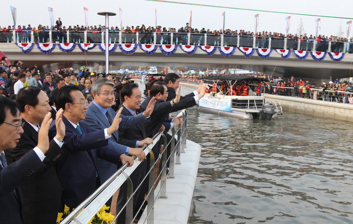 포항운하 통수기념식에 참석한 내빈들이 수상퍼레이드 행렬을 반기고 있다.